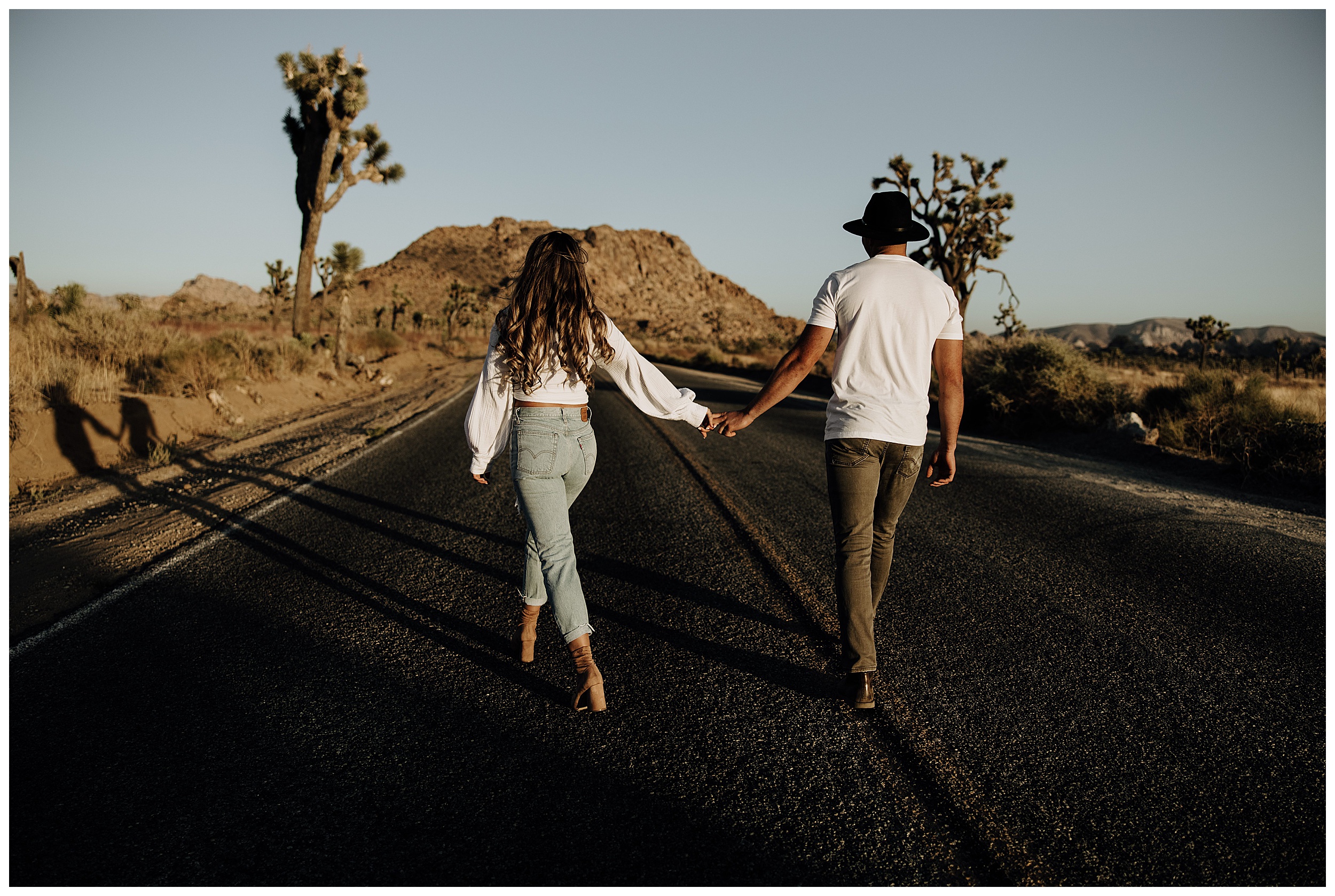 couple walking on a road at sunset