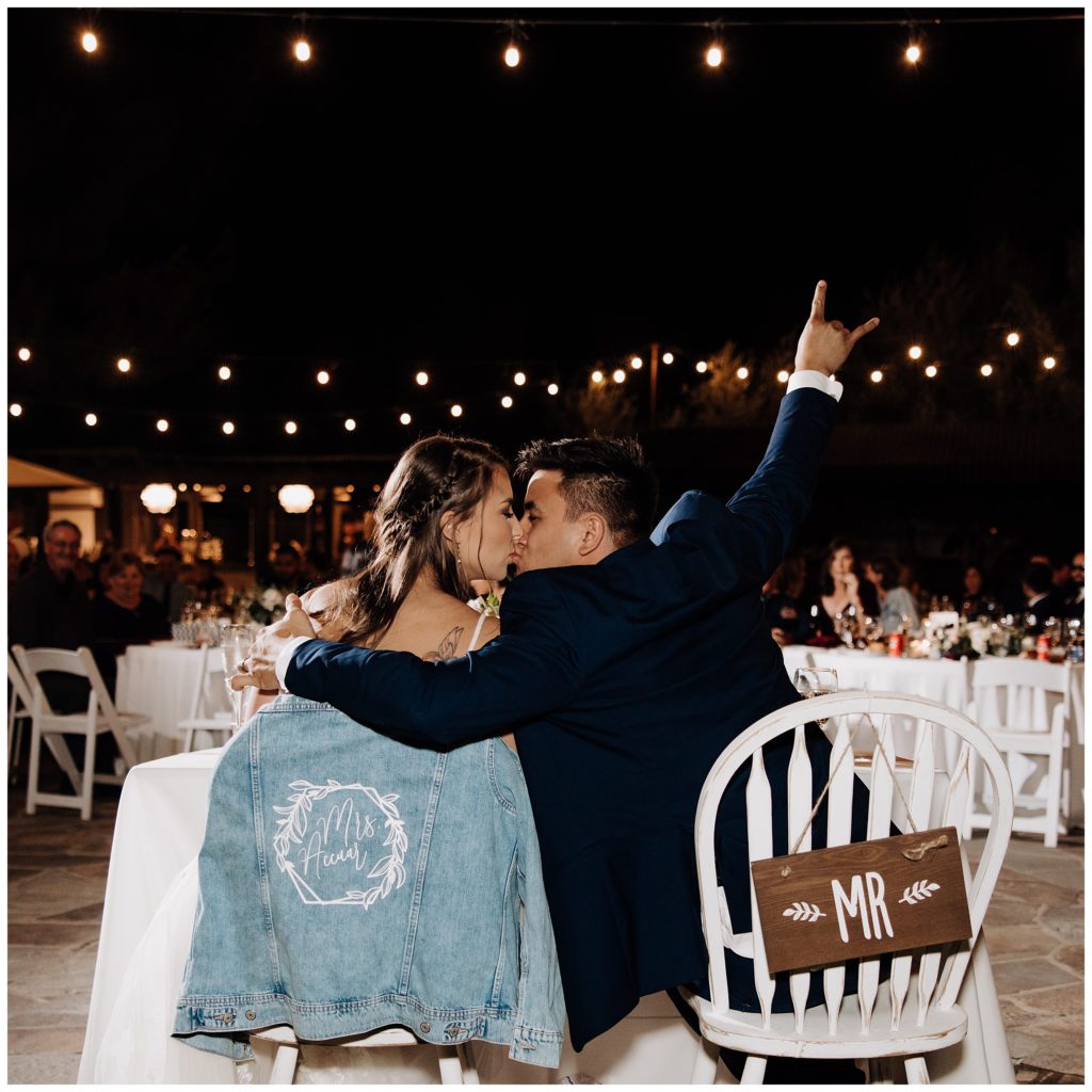 bride and groom kissing at sweetheart table