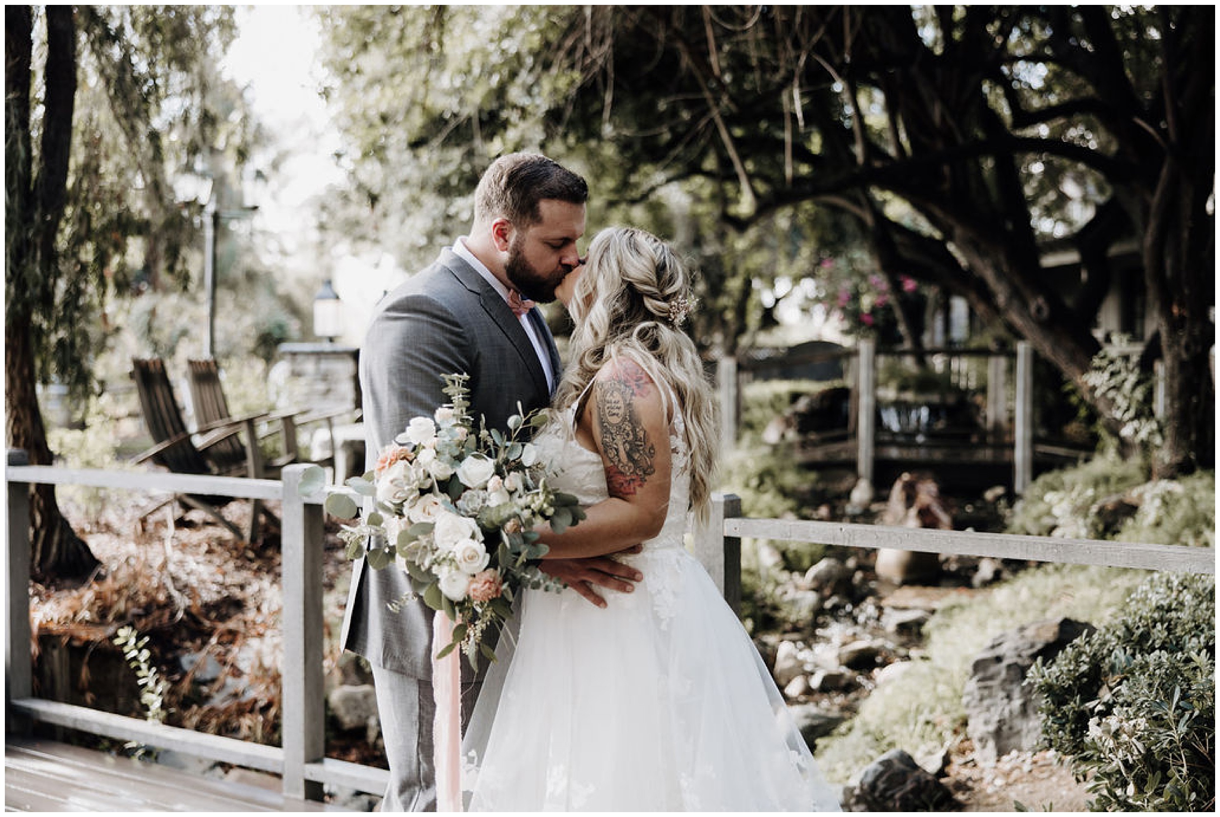 bride and groom kissing under tree