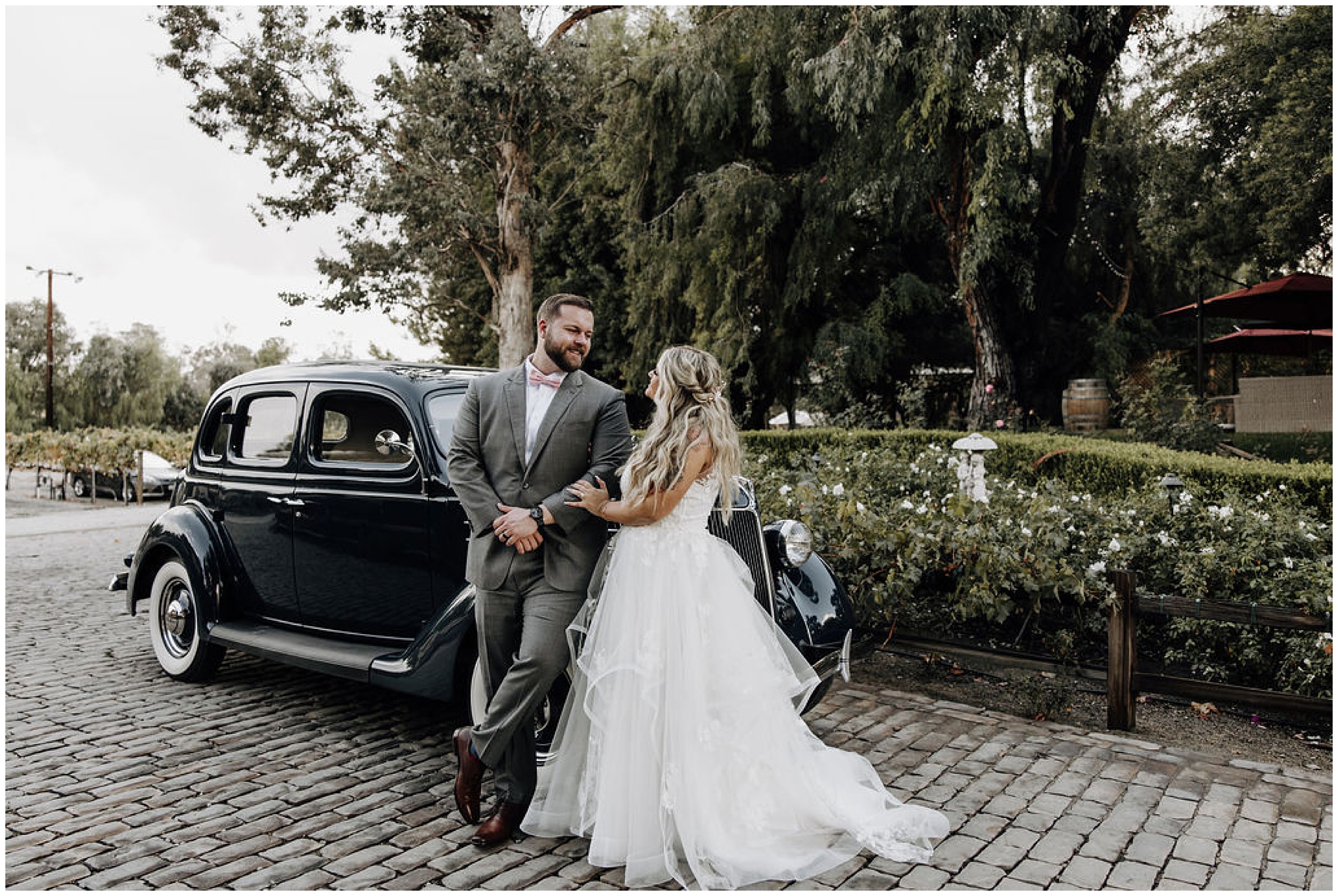 bride and groom standing by car