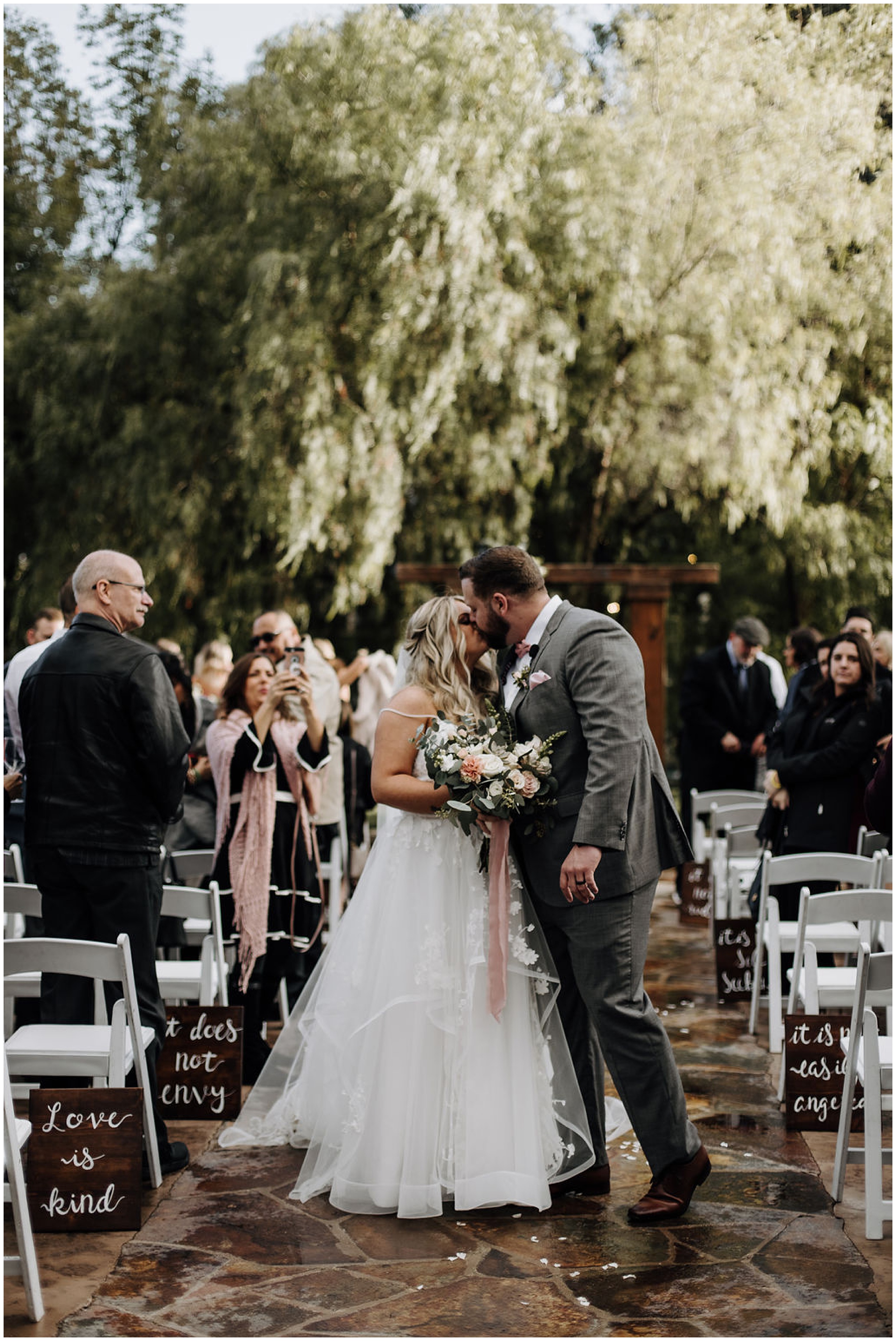 bride and groom walking down the aisle and kissing