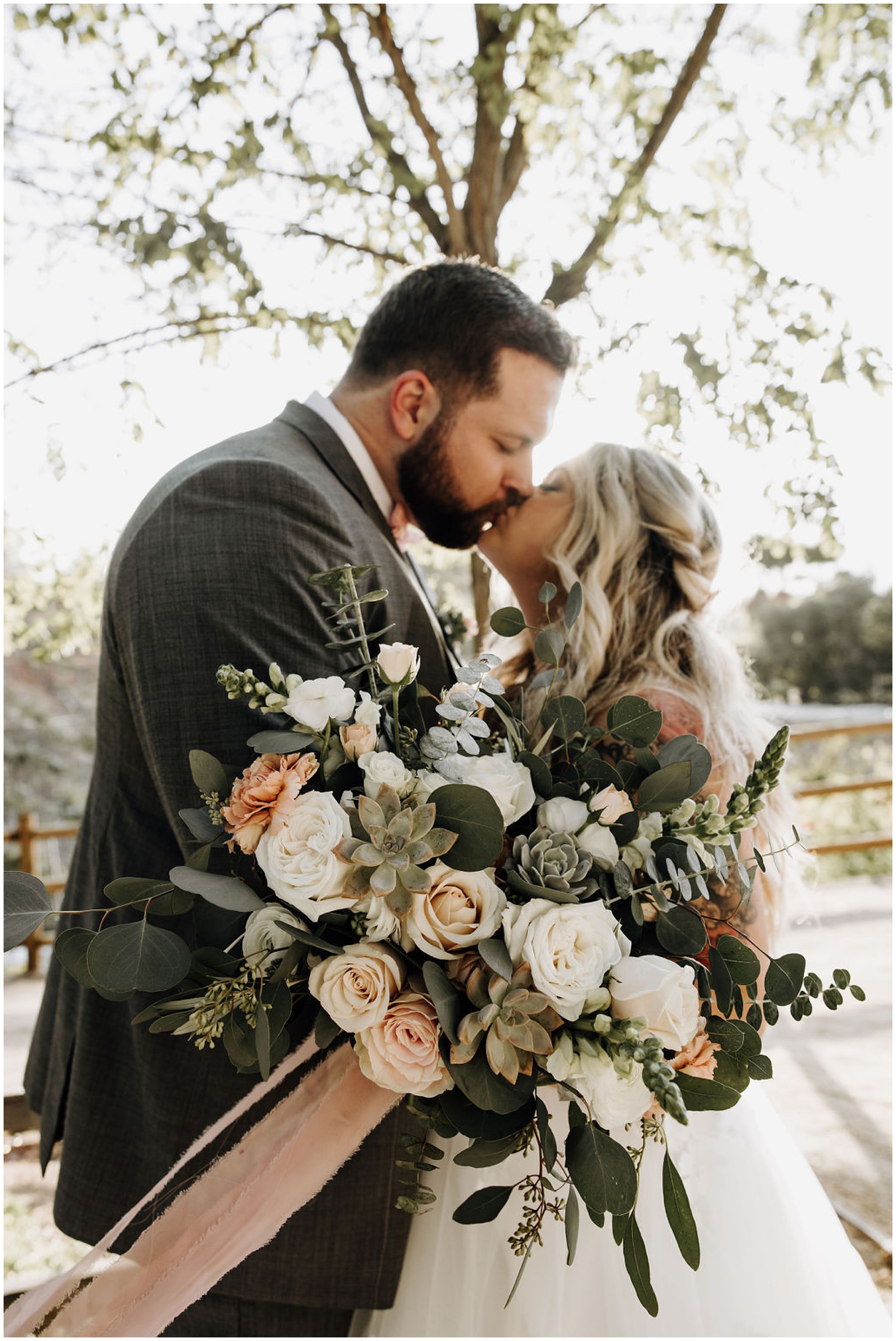 bride and groom kissing at sunset