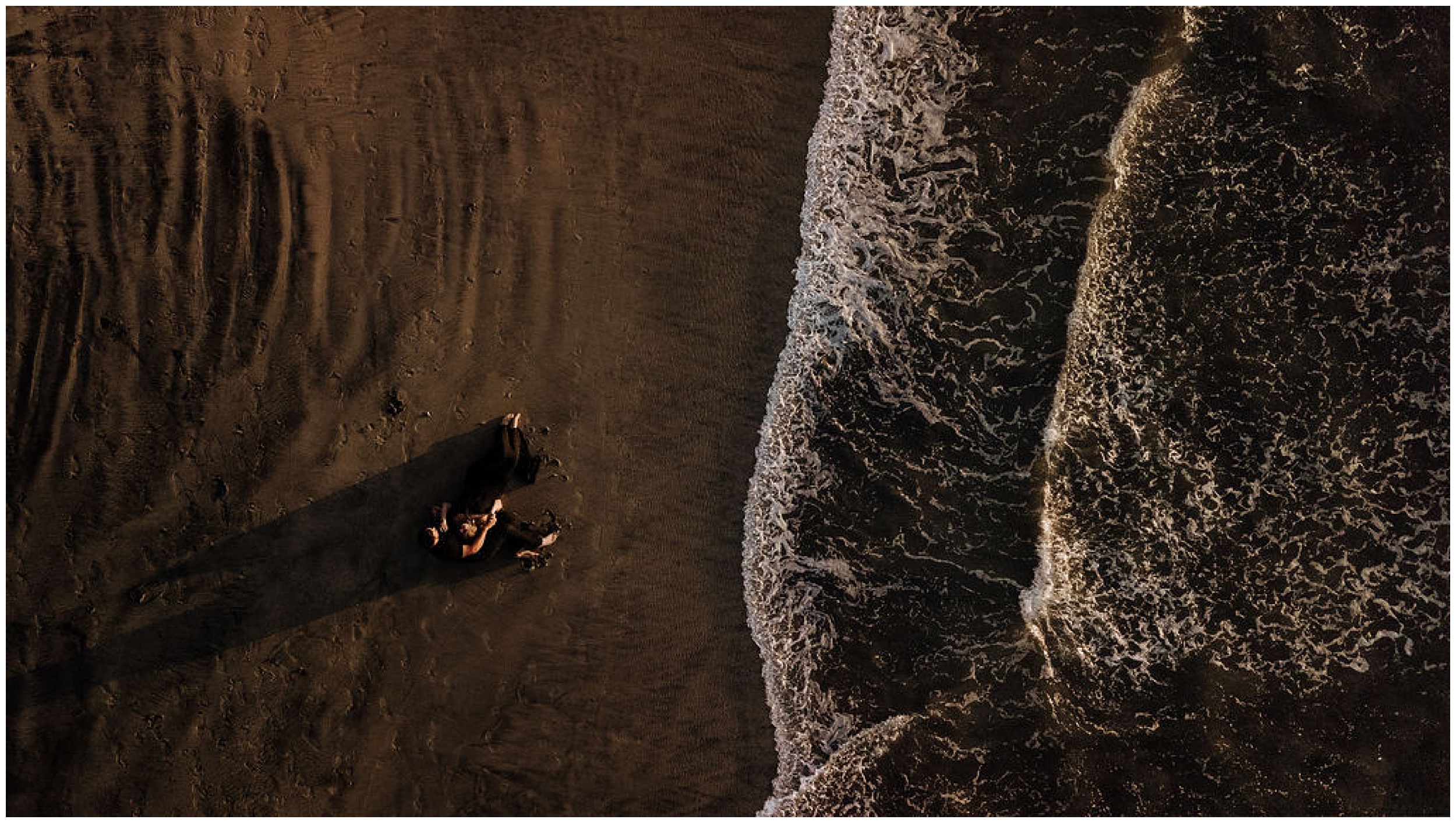 drone photo of couple lying on beach