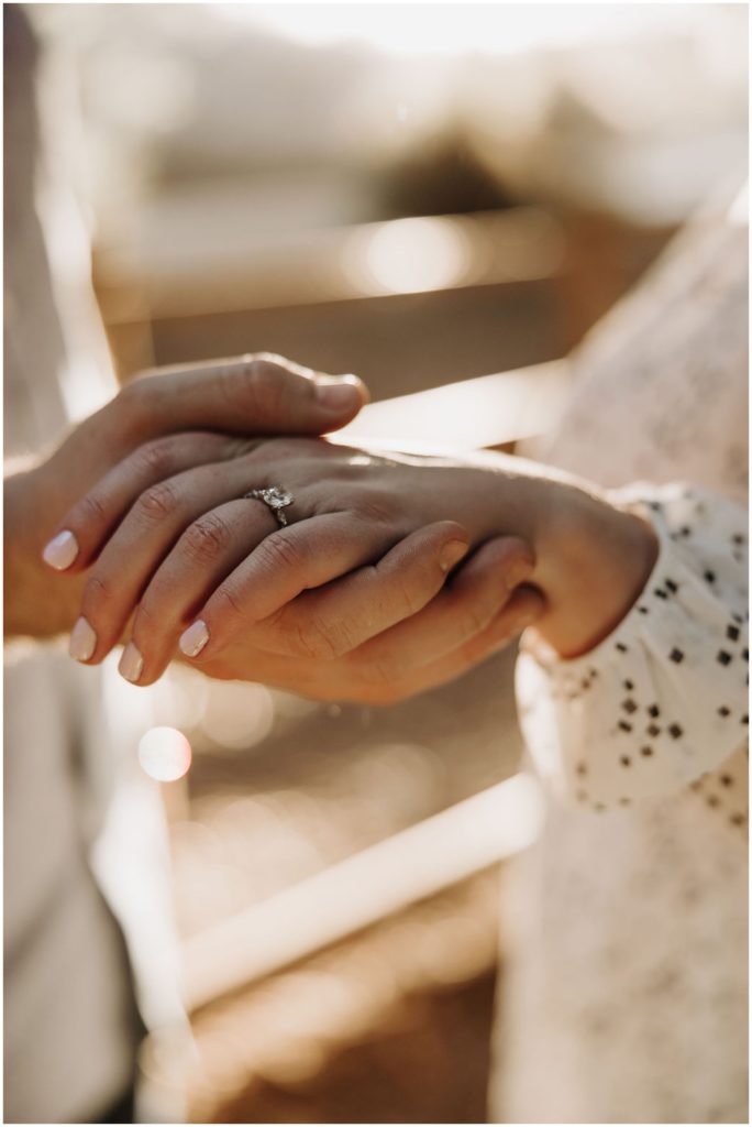 engaged couple holding hands