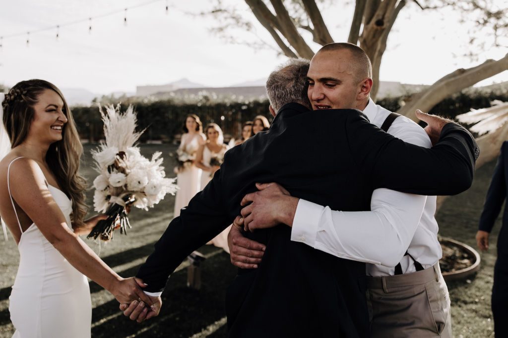 groom hugging brides dad