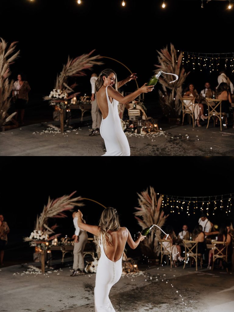 bride opening bottle of champagne with sword