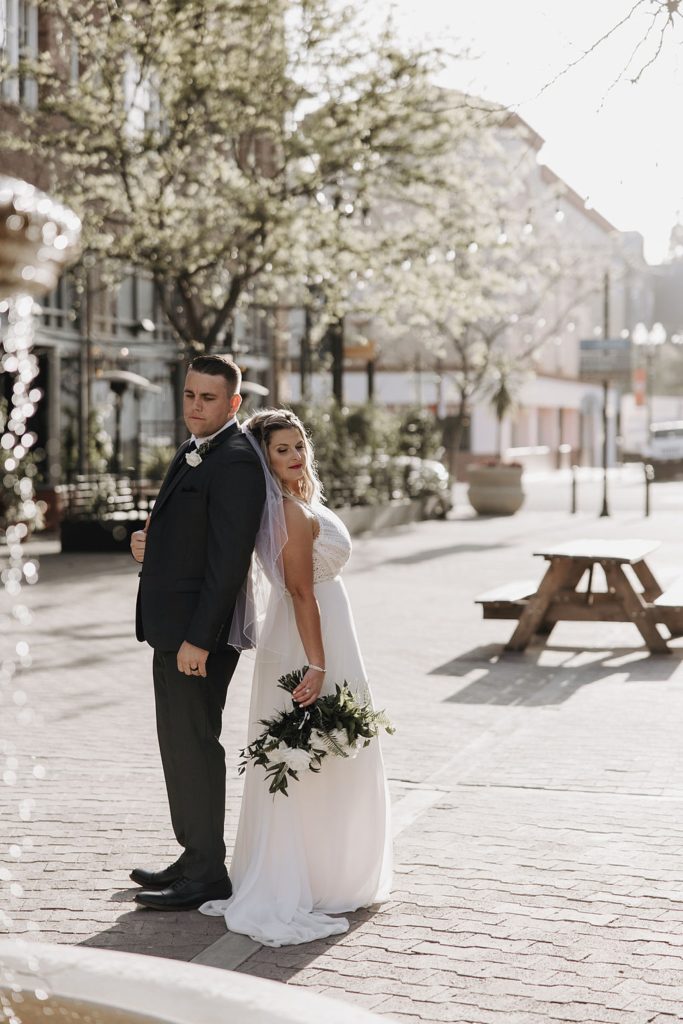 bride and groom standing back to back